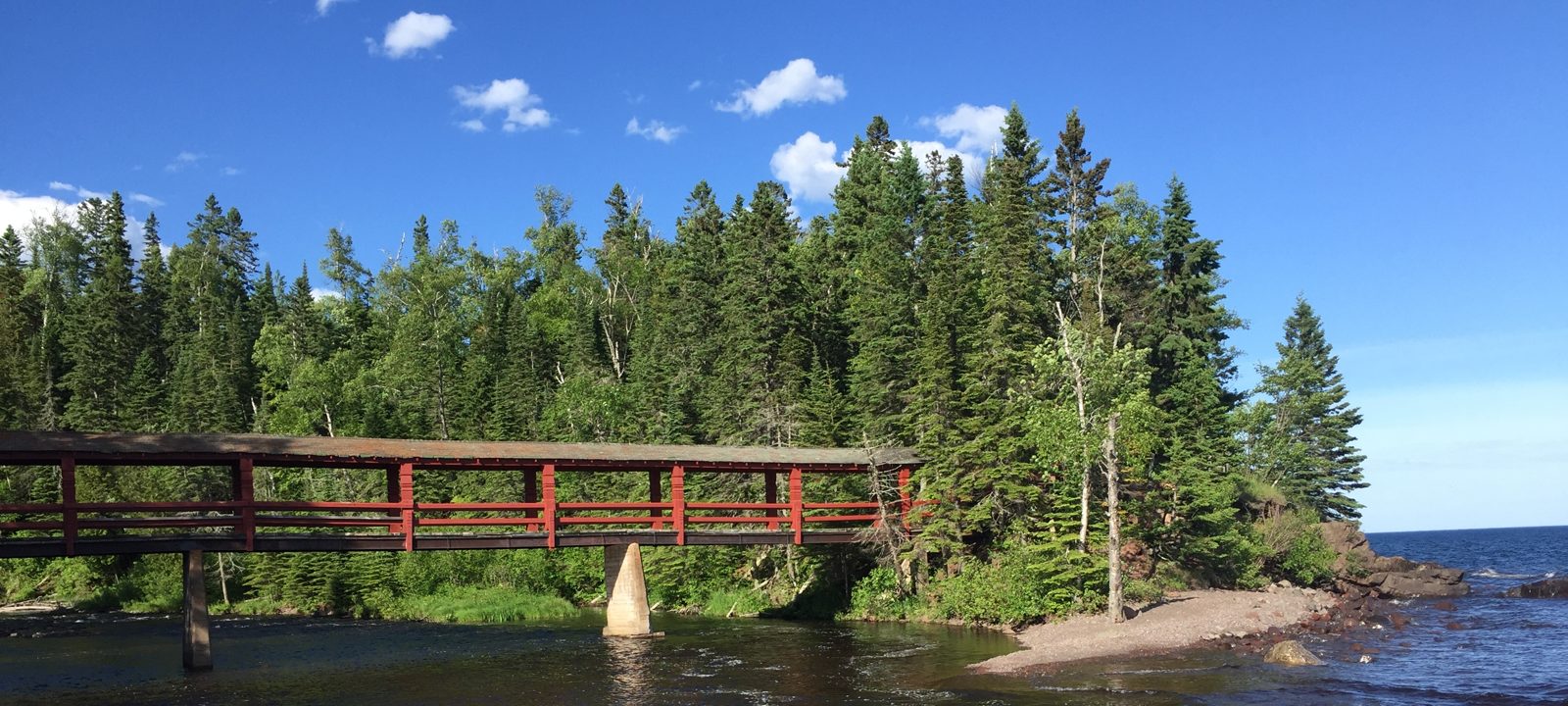 Red footbridge over the Poplar River where it meets Lake Superior